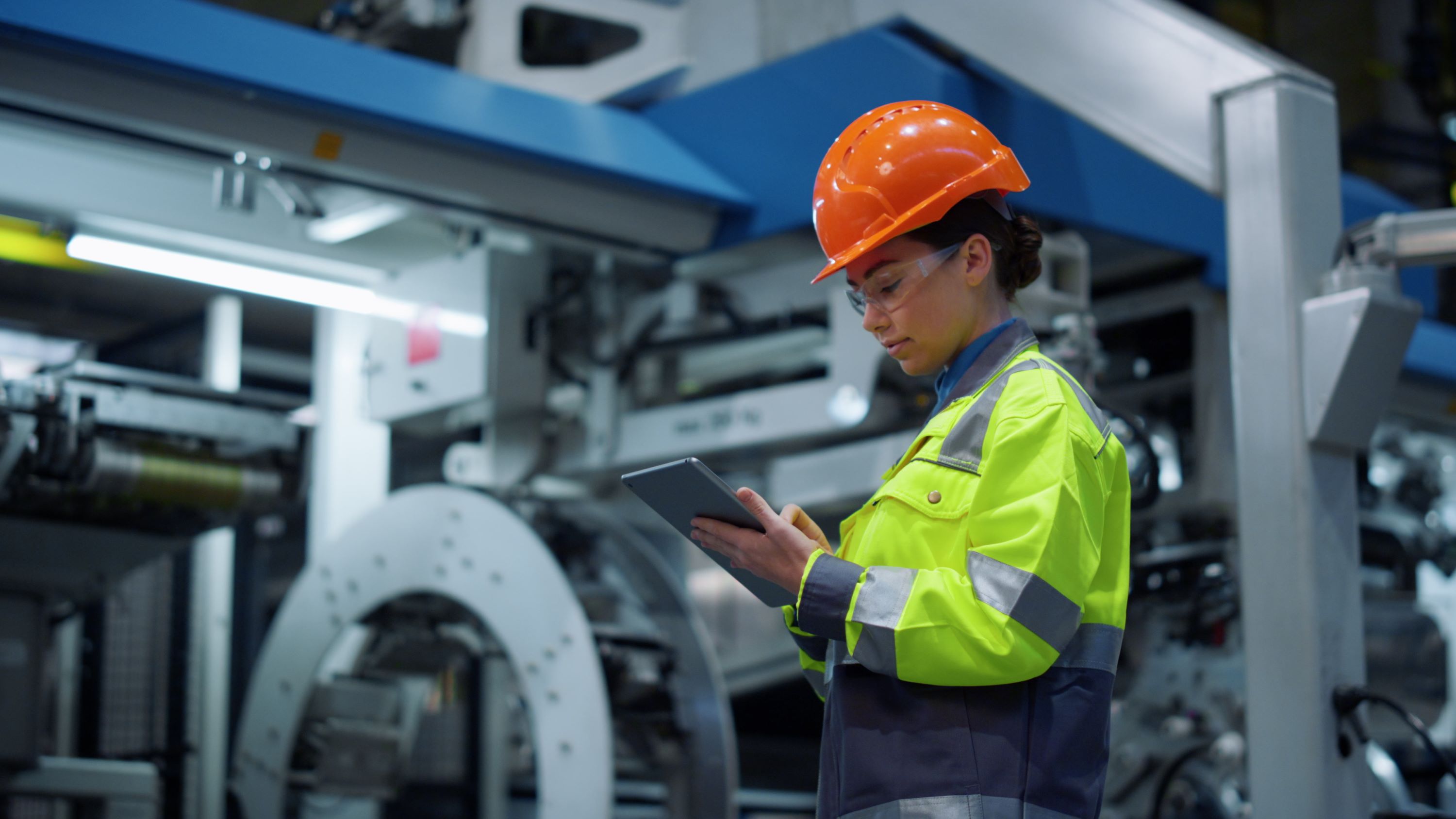 Energy worker holding a pad device at a facility.
