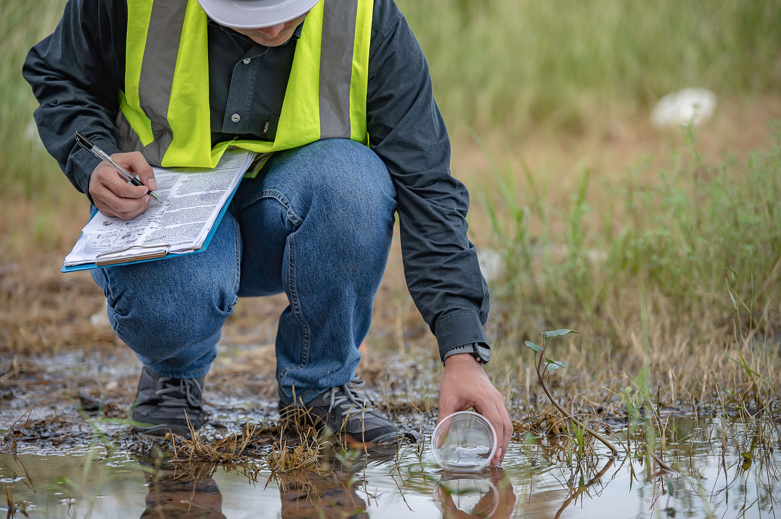Water utility professional procuring a water sample.
