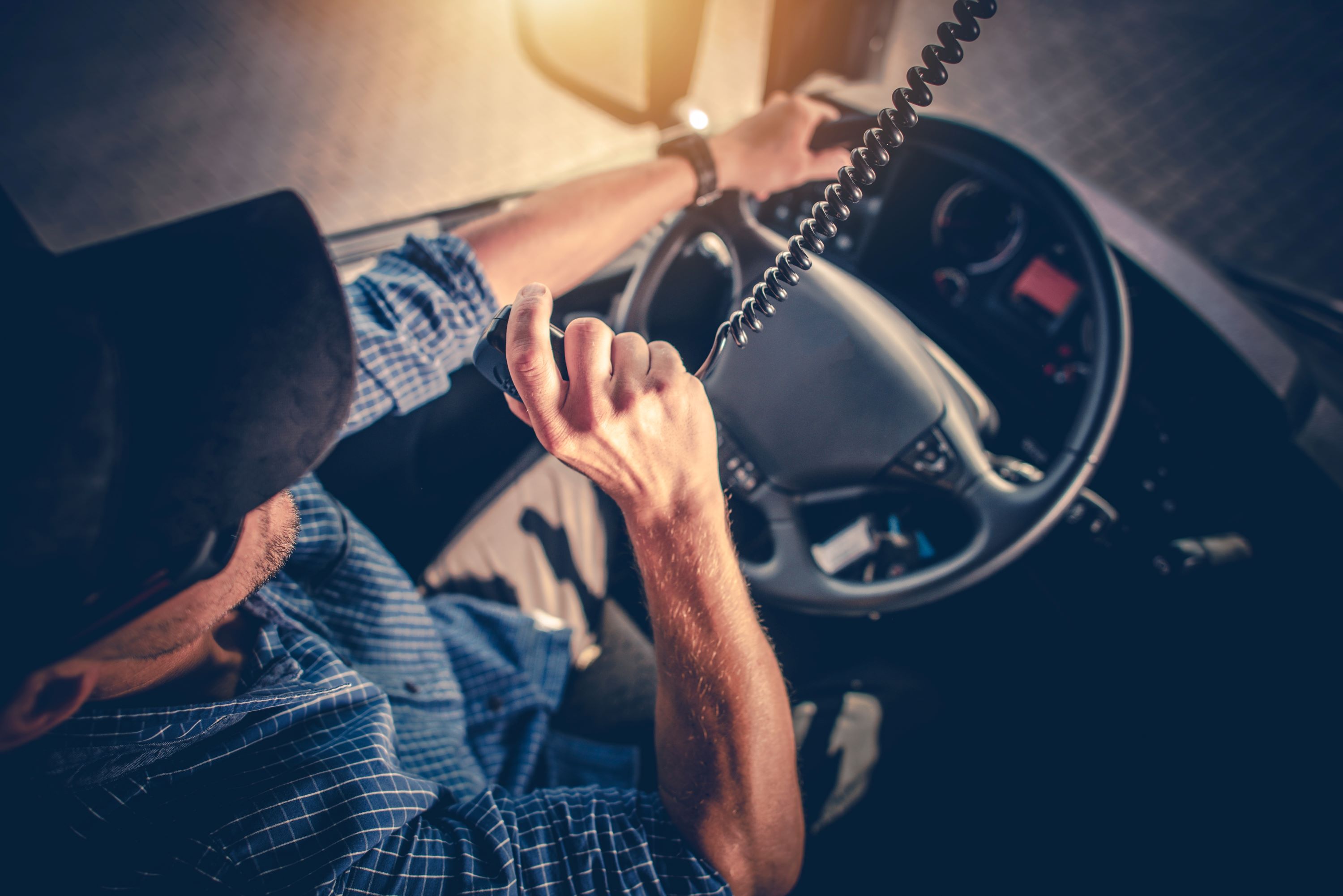 Truck driver behind the wheel using a CB radio.